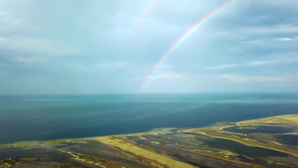 海の上の二重虹の空中ビュー 海と島の上の虹の空中ビュー 虹とDzharylgach島の空中ビュー 島の湖の空中ビューと二重虹 — ストック動画