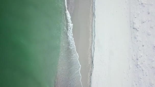 雪の白いビーチと海の波 ビーチと海の波の空中ビュー 海岸に到達する海の波の空中ドローン映像 ターコイズブルーの海の美しい波の空中ドローンビュー — ストック動画