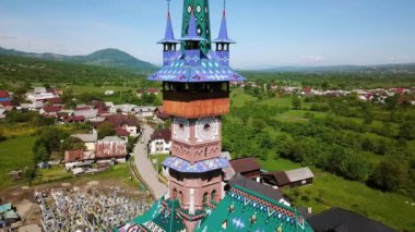Merry Mezarlığı 'ndaki kilisenin hava manzarası, Romanya' nın Maramures kentindeki Ruhani ve Neşeli Mezar Taşlarıyla Renkli Mezarlar, Mutlu Mezarlıkta süslenmiş mezar taşları.