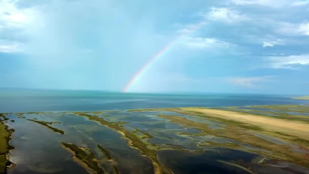 海の上の虹の空中ビュー 海と島の上の虹の空中ビュー 虹とDzharylgach島の空中ビュー 島と虹の湖の空中ビュー — ストック動画