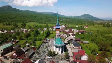Merry Mezarlığı 'ndaki kilisenin hava manzarası, Romanya' nın Maramures kentindeki Ruhani ve Neşeli Mezar Taşlarıyla Renkli Mezarlar, Mutlu Mezarlıkta süslenmiş mezar taşları.