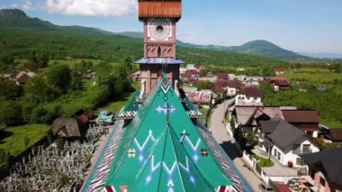 Merry Mezarlığı 'ndaki kilisenin hava manzarası, Romanya' nın Maramures kentindeki Ruhani ve Neşeli Mezar Taşlarıyla Renkli Mezarlar, Mutlu Mezarlıkta süslenmiş mezar taşları.