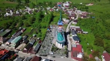 Merry Mezarlığı 'ndaki kilisenin hava manzarası, Romanya' nın Maramures kentindeki Ruhani ve Neşeli Mezar Taşlarıyla Renkli Mezarlar, Mutlu Mezarlıkta süslenmiş mezar taşları.