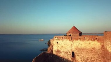 Gün batımında deniz üzerindeki kalenin havadan görünüşü, gün batımında Akerman Kalesi 'nin havadan görünüşü, Bilhorod' daki Dinyester halklarının kıyısındaki Akkerman antik kalesinin üzerinde uçan insansız hava aracı.