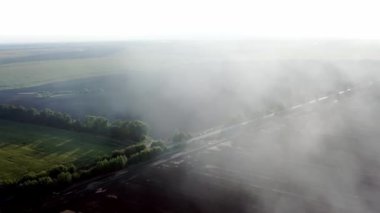 Bir tarlanın üzerindeki yangından çıkan dumanın havadan görünüşü drone çiftçisinin kuru otları yakması, hava sahasında yangın, sonbahar tarlalarında yangın.