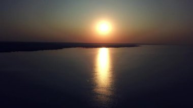 Deniz üzerinde günbatımının havadan görünüşü, güzel gündoğumu okyanus, akşam dalgaları, gün batımında su yüzeyinde güzel yansımalar.