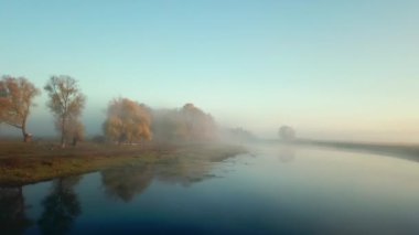 Nehir kenarındaki sonbahar ağaçlarının hava manzarası, sabahları sonbahar ağaçlarının hava manzarası, sabah sisli bir nehir, nehrin üzerindeki güneşli ve sisli bir sabah.