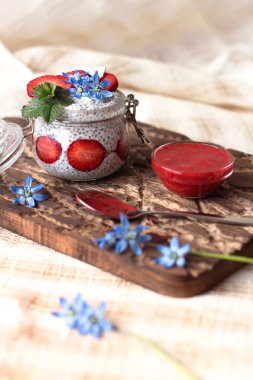 Chia puding keten masa örtüsü üzerinde küçük kase çilek ile