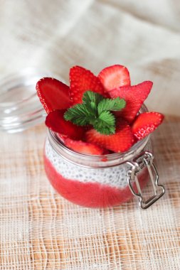 Chia puding keten masa örtüsü üzerinde küçük kase çilek ile