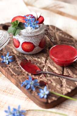 Chia puding keten masa örtüsü üzerinde küçük kase çilek ile
