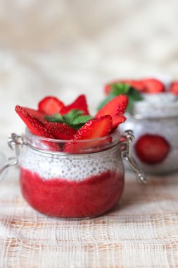Chia puding keten masa örtüsü üzerinde küçük kase çilek ile