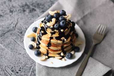 Yaban mersini ve beton zemin üzerine çikolata sosu ile krep yığını