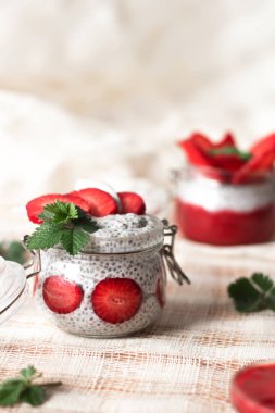 Chia puding keten masa örtüsü üzerinde küçük kase çilek ile