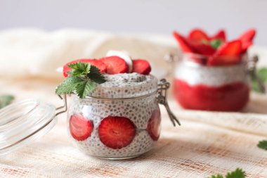 Chia puding keten masa örtüsü üzerinde küçük kase çilek ile