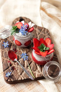 Chia puding keten masa örtüsü üzerinde küçük kase çilek ile