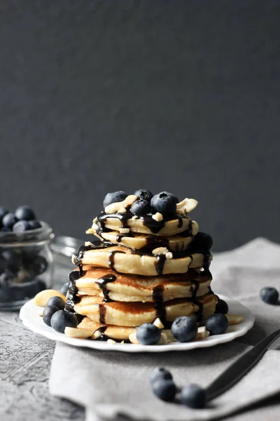 Yaban mersini ve beton zemin üzerine çikolata sosu ile krep yığını