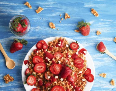 Waffle ile çilek mavi zemin üzerine beyaz tabakta. Üstten Görünüm düz yatıyordu