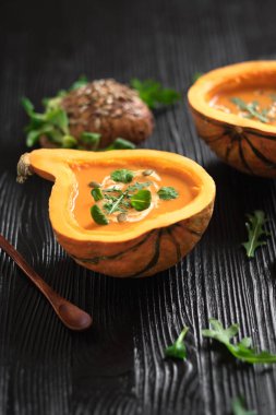 Yarım kabak çorbası siyah arka plan ile. Dikey kompozisyon. Yeşil ve sebzeler