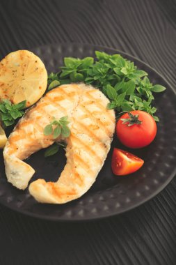 Limon ve fesleğen koyu arka plan üzerinde ızgara somon.