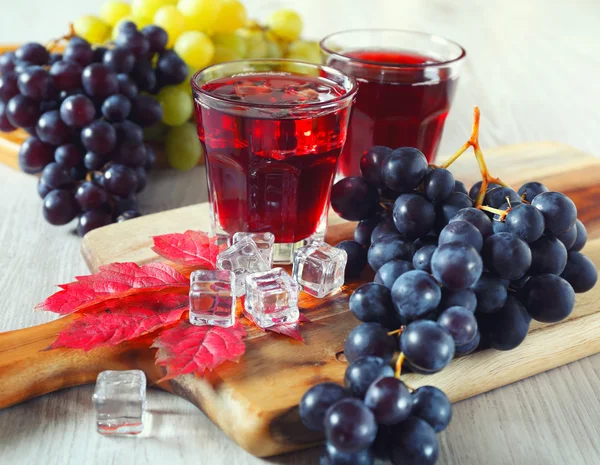Стаканы виноградного сока и черный и зеленый виноград — стоковое фото