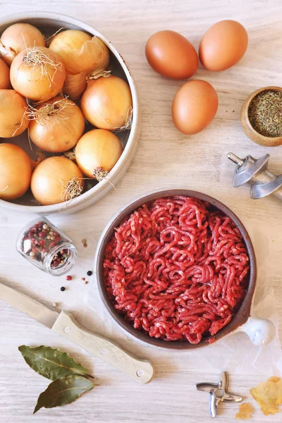 Raw minced meat, eggs, olive oil and onions — Stock Photo, Image