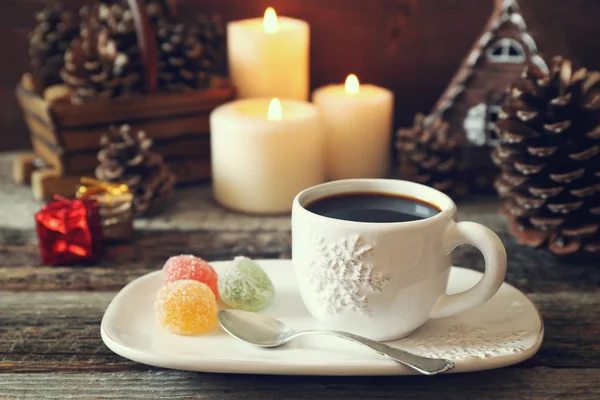 Taza de café, conos de pino, velas encendidas y dulces de colores — Foto de Stock