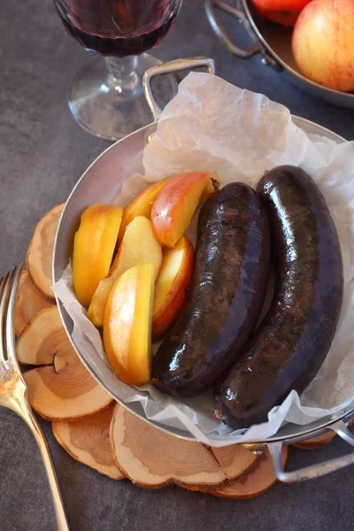Французская кухня: Кровавая колбаса, яблоки и бокал красного вина — стоковое фото