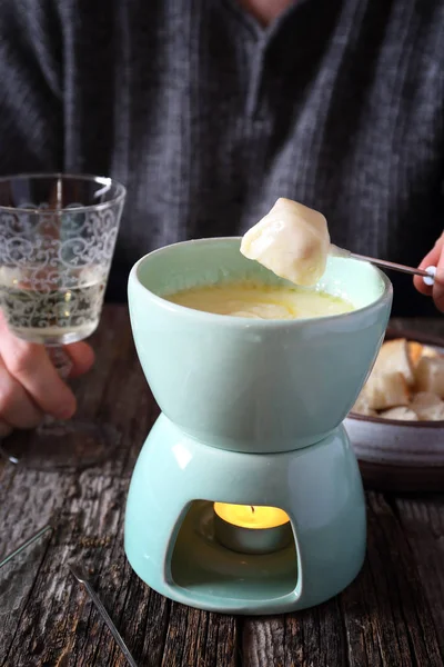 Cheese fondue with baguette and glass of white wine