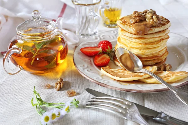Pfannkuchen mit Karamellsoße, Erdbeeren und Kräutertee — Stockfoto