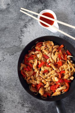 Kızarmış domuz eti kırmızı biber ve sıcak Asya sos, yemek çubukları ile