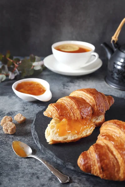 Two fresh croissants, jam and lemon tea — Stock Photo, Image