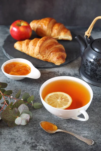 Λεμόνι τσάι, μαρμελάδα και δύο φρέσκα κρουασάν — Φωτογραφία Αρχείου