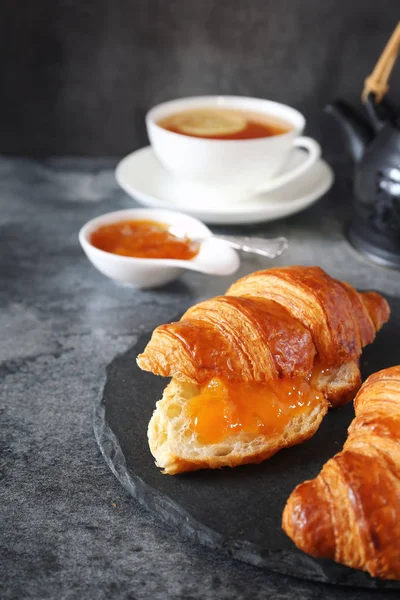 Two fresh croissants, jam and lemon tea — Stock Photo, Image
