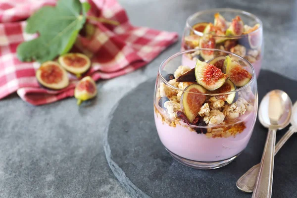 Deux verres de yaourt aux fruits avec granola, figues et miel — Photo