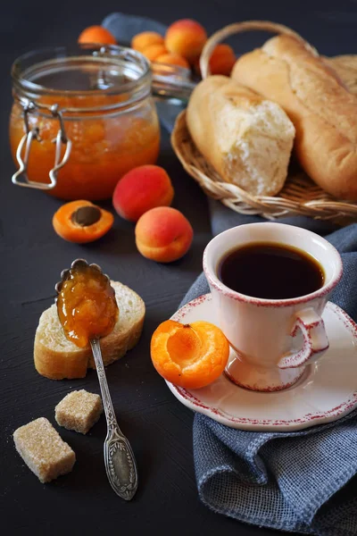 Абрикоси, абрикосове варення у вареній банці та чашці кави — стокове фото