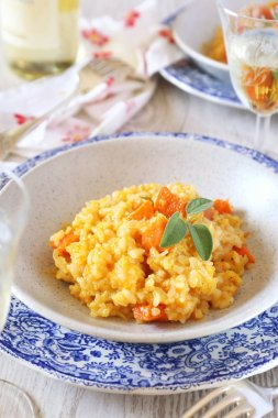 Balkabağı risotto ve bardak beyaz şarap 