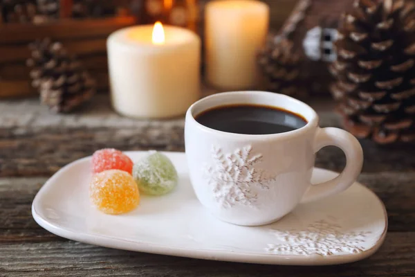Weihnachtsgetränk: Kaffee, bunte Bonbons und brennende Kerzen — Stockfoto