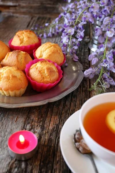 Spring tea: lemon muffins, tea and flowering blue wisteria — Stock Photo, Image