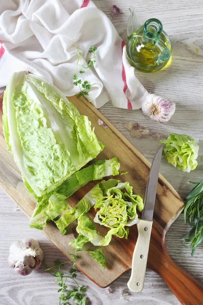 Здорове харчування: салат, часник та оливкова олія на обробній дошці — стокове фото