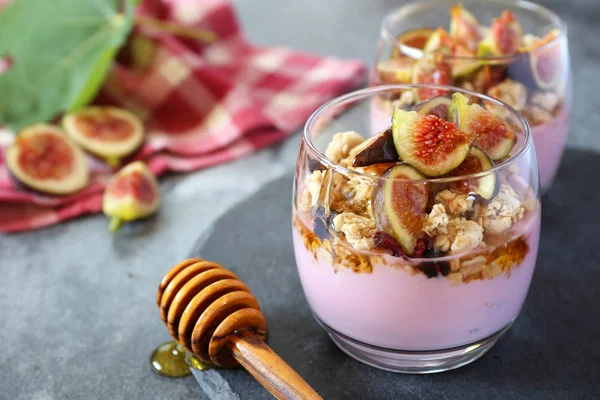 Deux verres de yaourt aux fruits avec granola, figues et miel pour lig — Photo