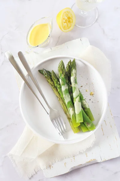 French cuisine. Fresh green asparagus with hollandaise sauce — Stock Photo, Image