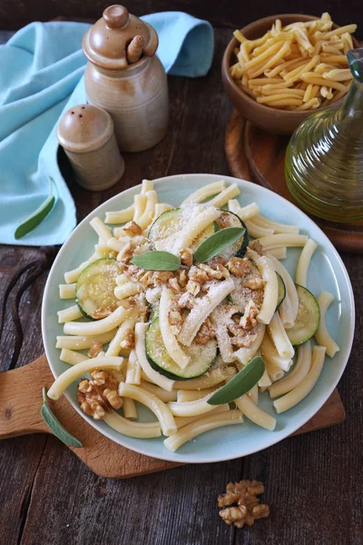 Penne pasta with roasted zucchini, grated parmesan cheese and walnuts — Stock Photo, Image