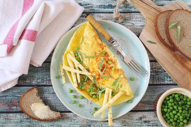 Mavi tabakta sert peynirli bezelye omleti ve kahvaltıda çavdar ekmeği.