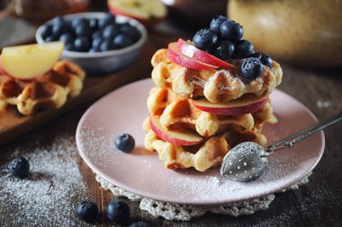 Kahvaltı için yabanmersinli ve elmalı geleneksel Belçika waffleları.