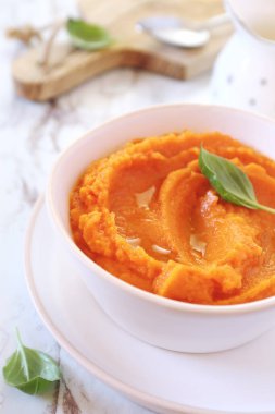 Hafif seramik tabakta havuç püresi ve fesleğen sosu.