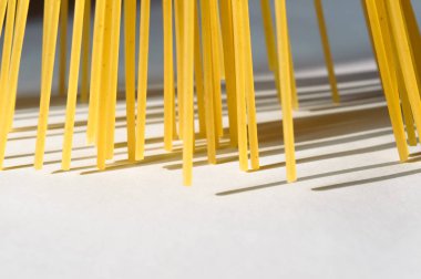Spagetti dikey olarak beyaz bir backgr üzerinde güneş ışığı altında duruyor.