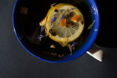 Bir fincan çay limon ve portakal kabuğu siyah tablo ile. Sayfanın Üstü 