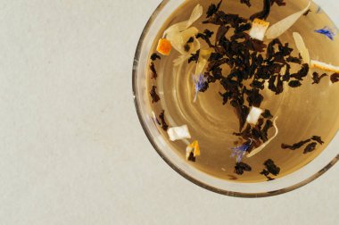 Siyah çay yaprakları bir saydam mavi çiçekler, portakal kabuğu ile