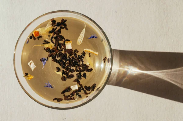 Siyah çay yaprakları bir saydam mavi çiçekler, portakal kabuğu ile