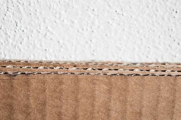 Texture of brown cardboard side. Folded cardboard boxes against — Stock Photo, Image